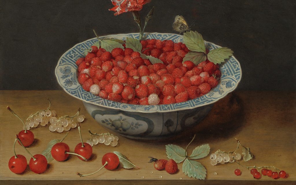 still life of bowl of raspberries and a flower. some raspberries lay fallen on the table around the bowl